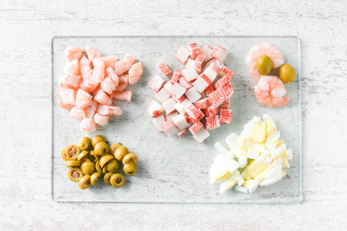 Cortamos el huevo, el surimi, las aceitunas y las gambas