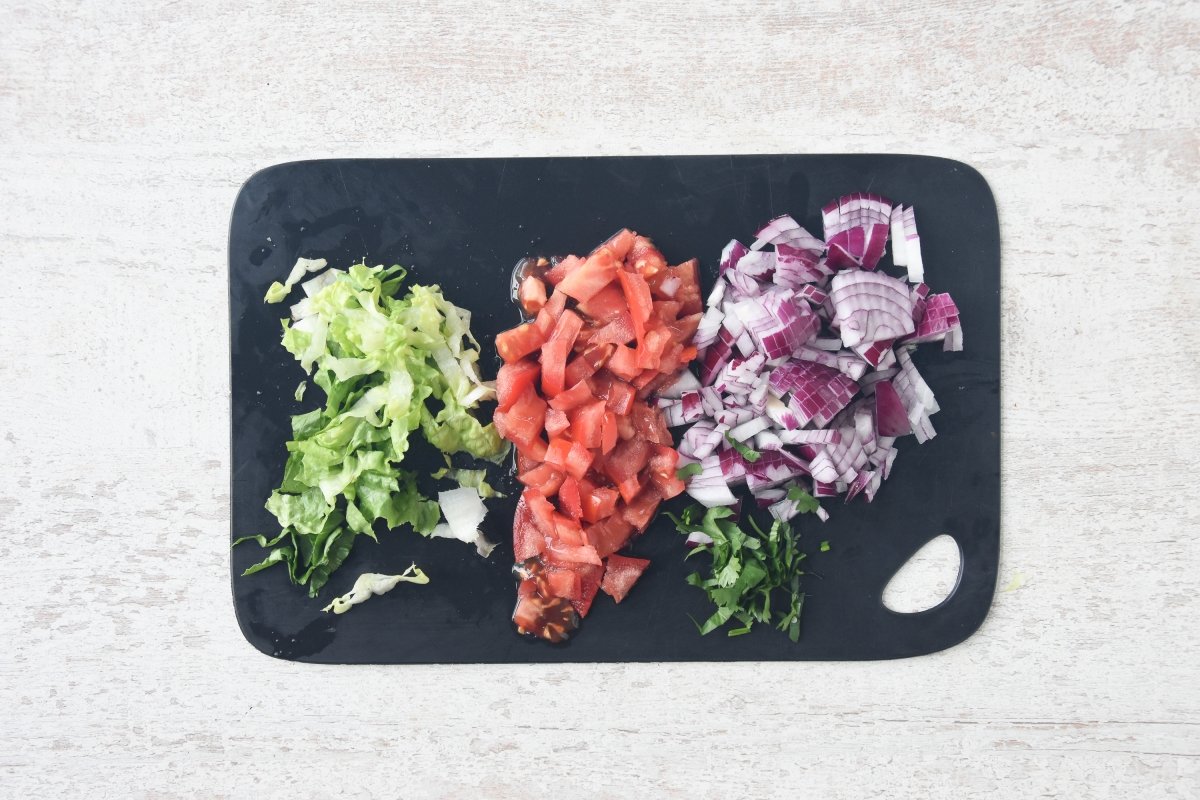 Cortamos la lechuga, tomate, cebolla roja y cilantro