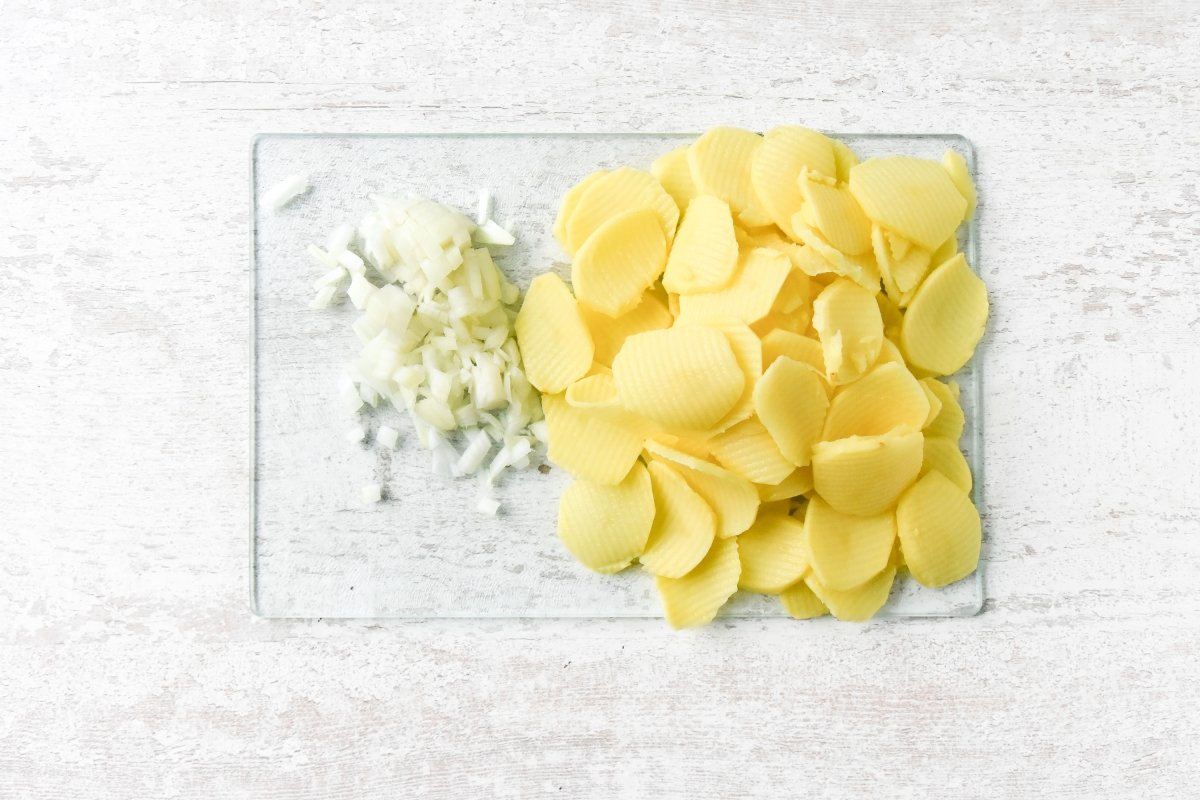Cortamos las patatas y la cebolla para la tortilla vegana