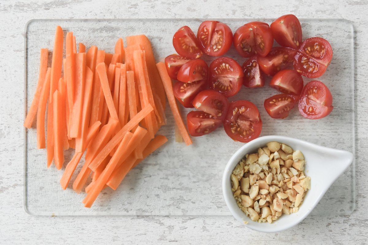 Cortamos los tomates, las zanahorias y los cacahuetes