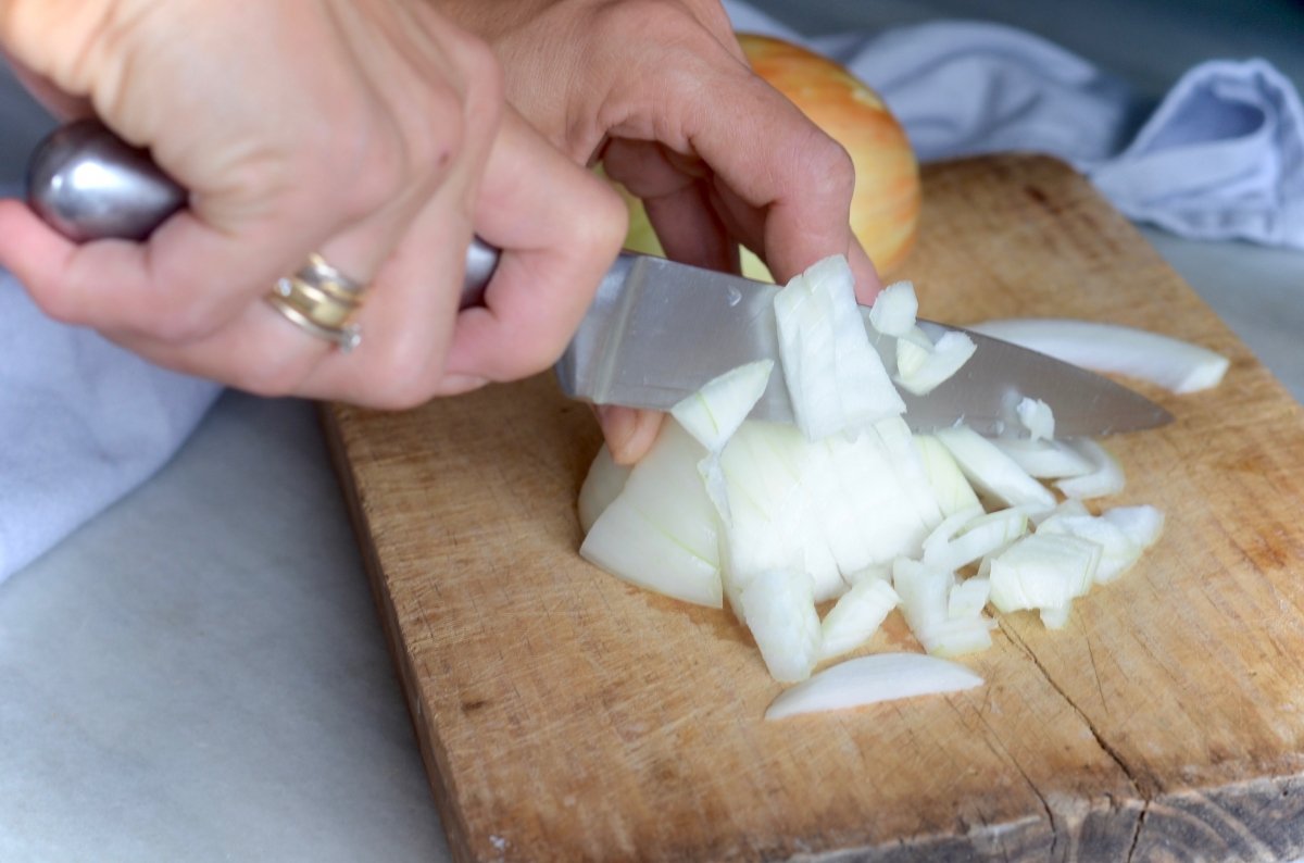 Cortando la cebolla a mano para la empanada de bonito