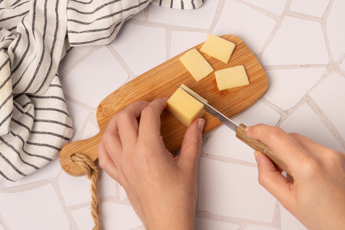 Cortando queso para adornar el pastel de arroz al vapor