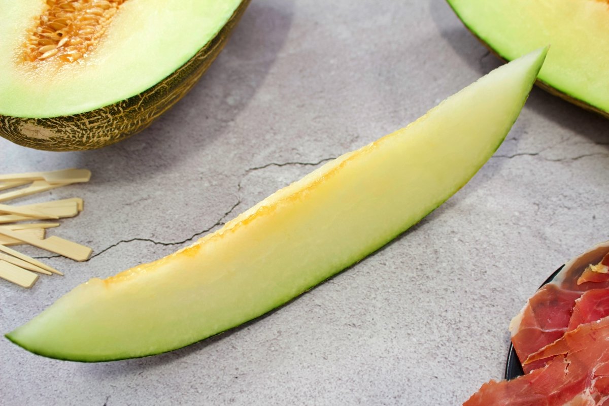 Cortando rodajas de melón para hacer el melón con jamón