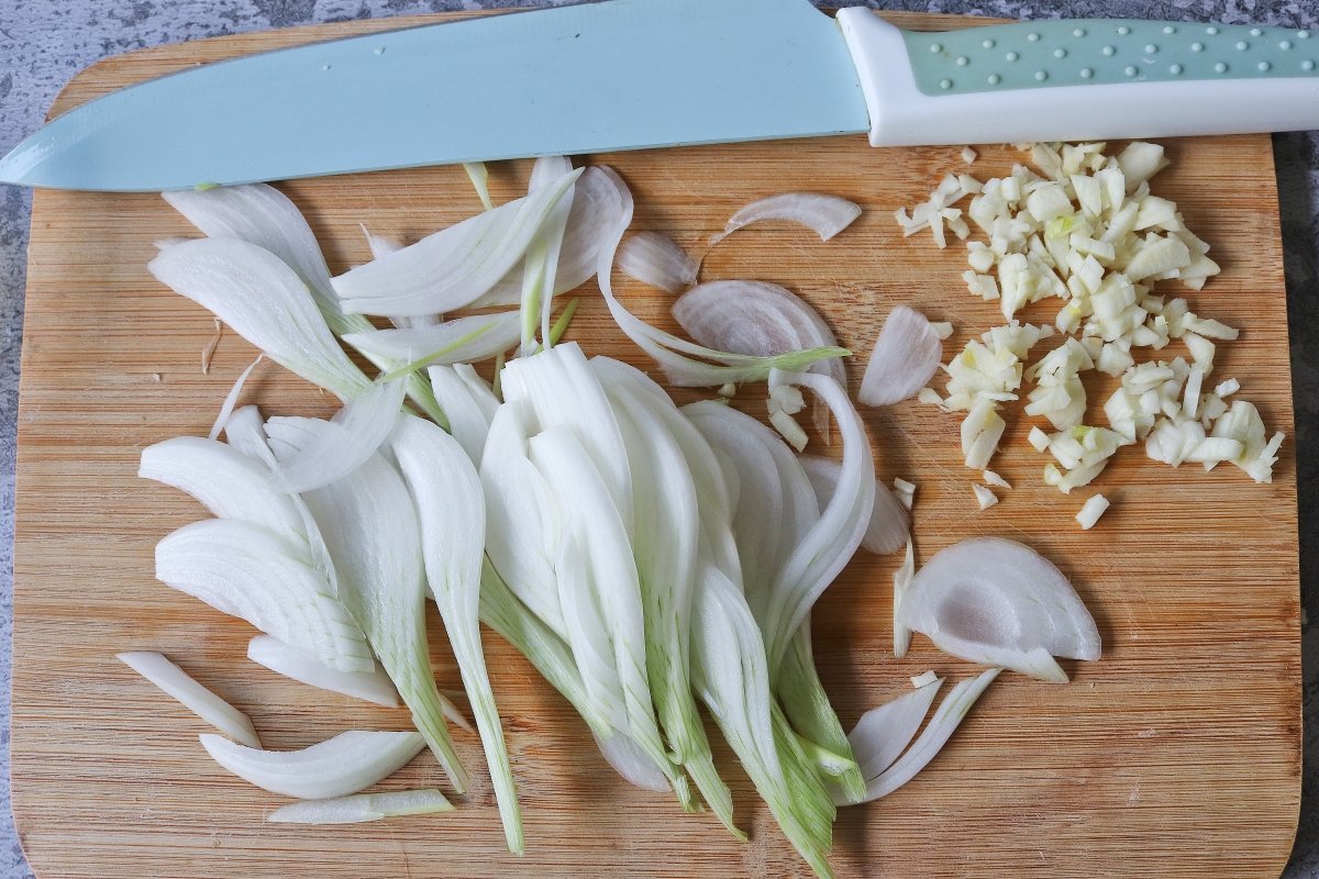 Cortar la cebolla y el ajo para el pad thai