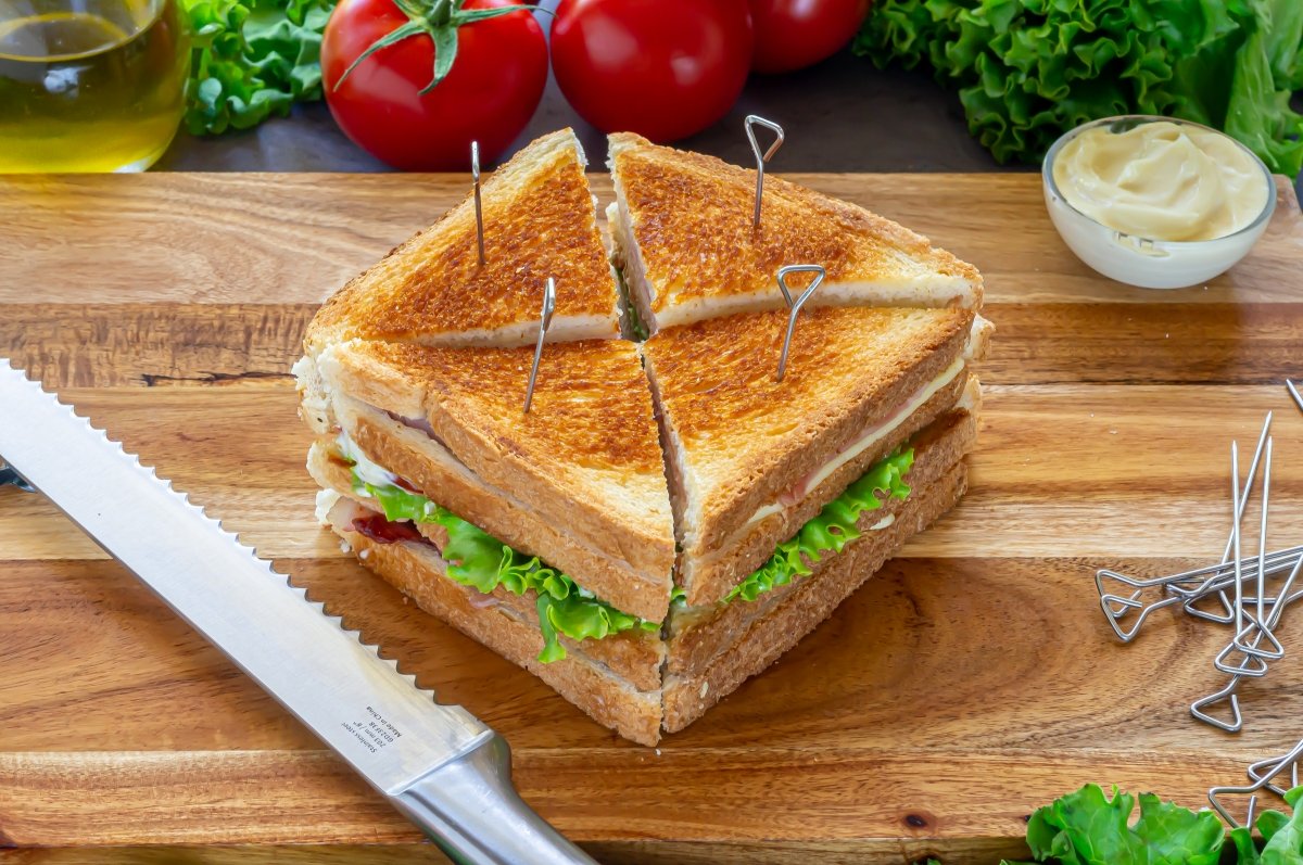 Cortar el sándwich club en triángulos