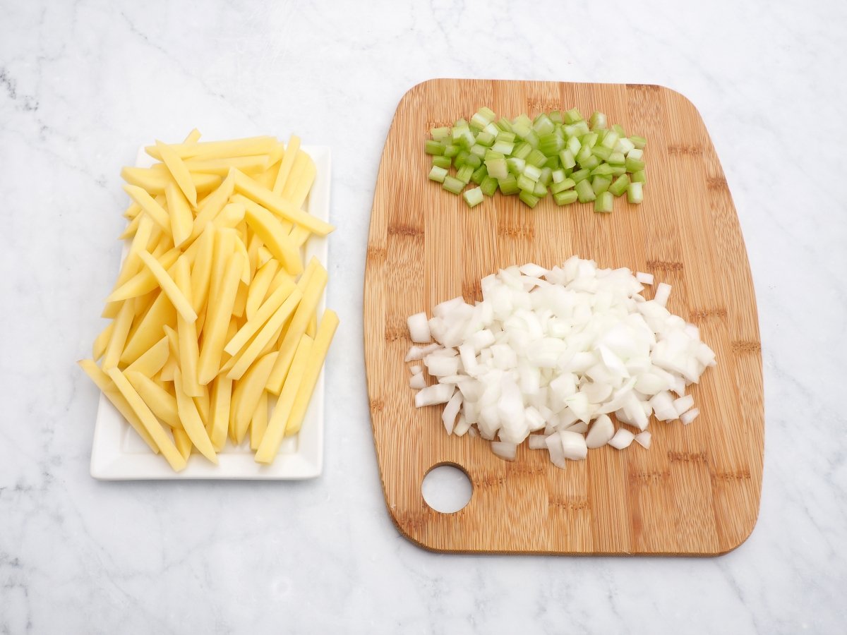 Cortar la cebolla, el apio y las patatas