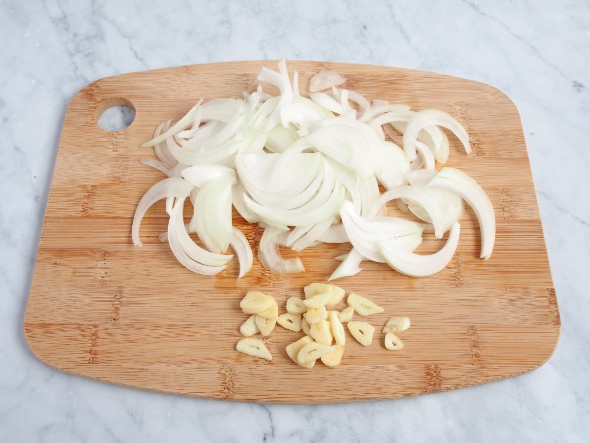 Cortar la cebolla y el ajo para el pollo en pepitoria