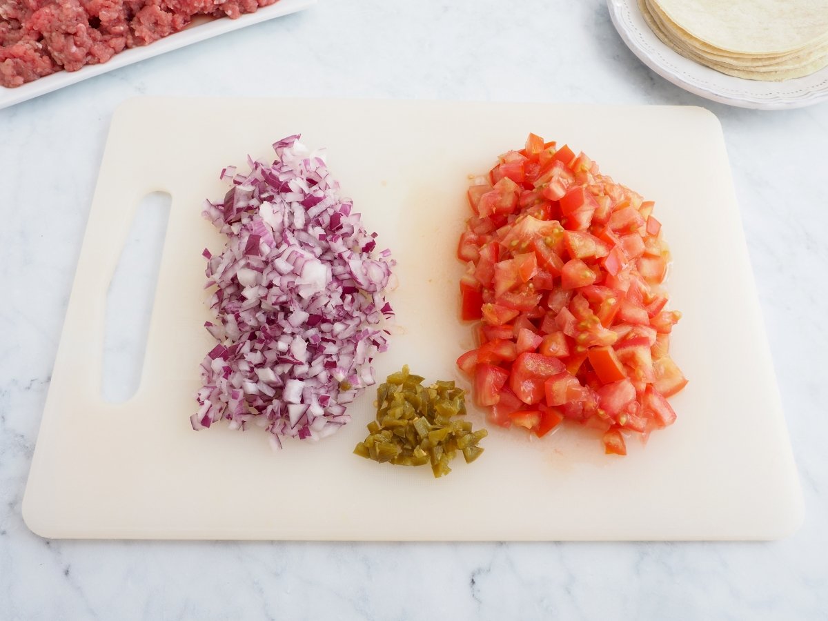 Cortar la cebolla y el tomate para los tacos