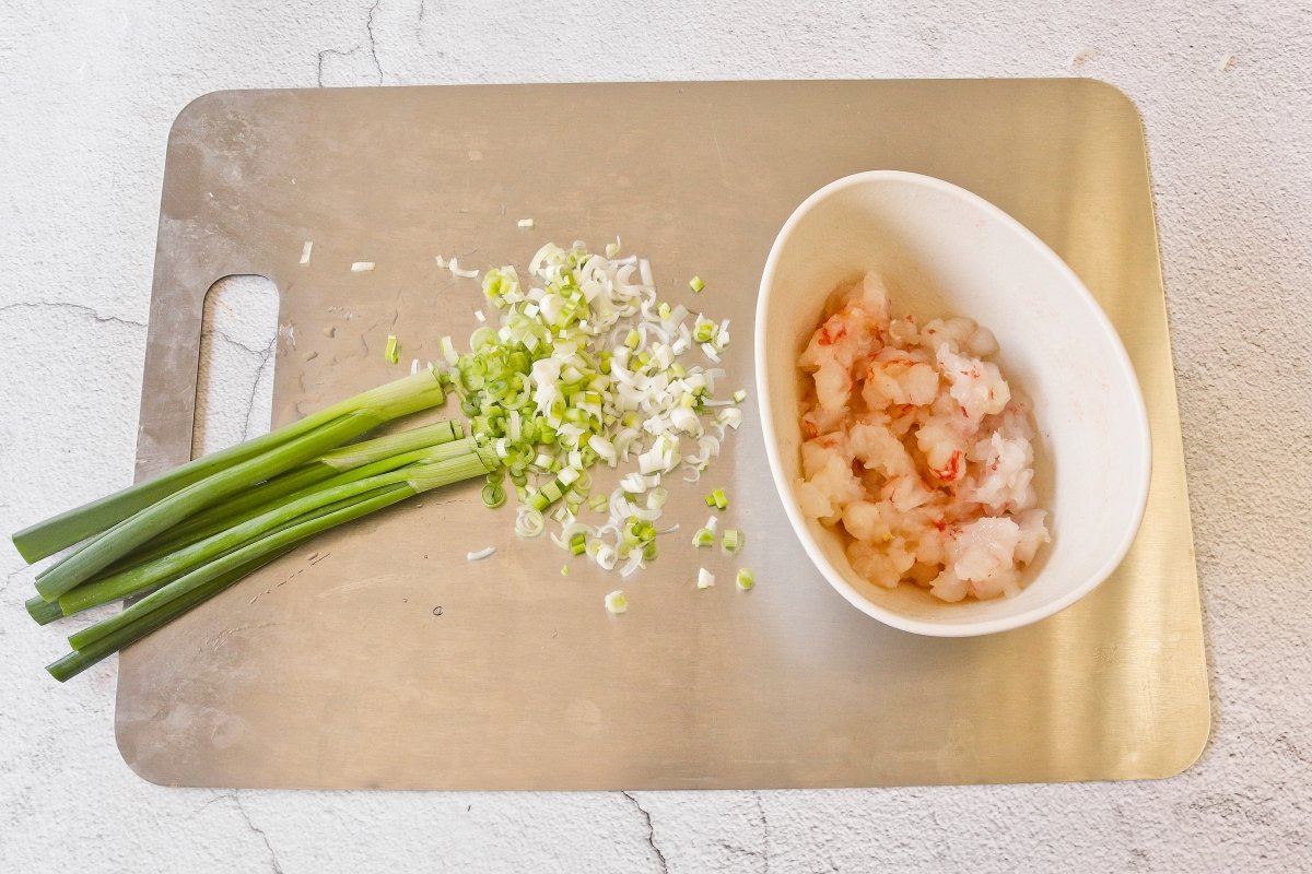 Cortar la cebolleta y los langostinos del relleno de los wan tuns para hacer la sopa
