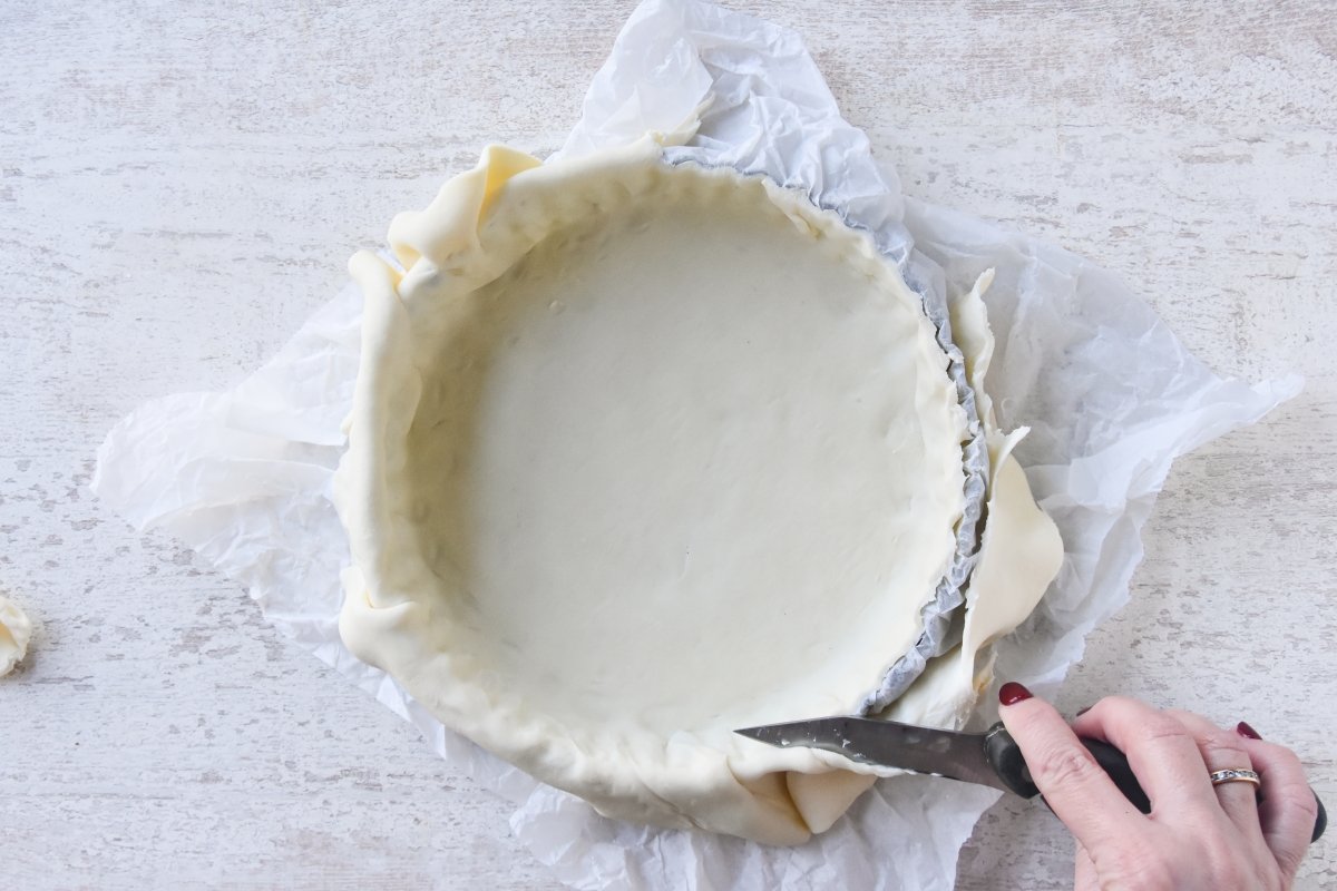 Cortar la masa para forrar el molde de la tarta de frutas