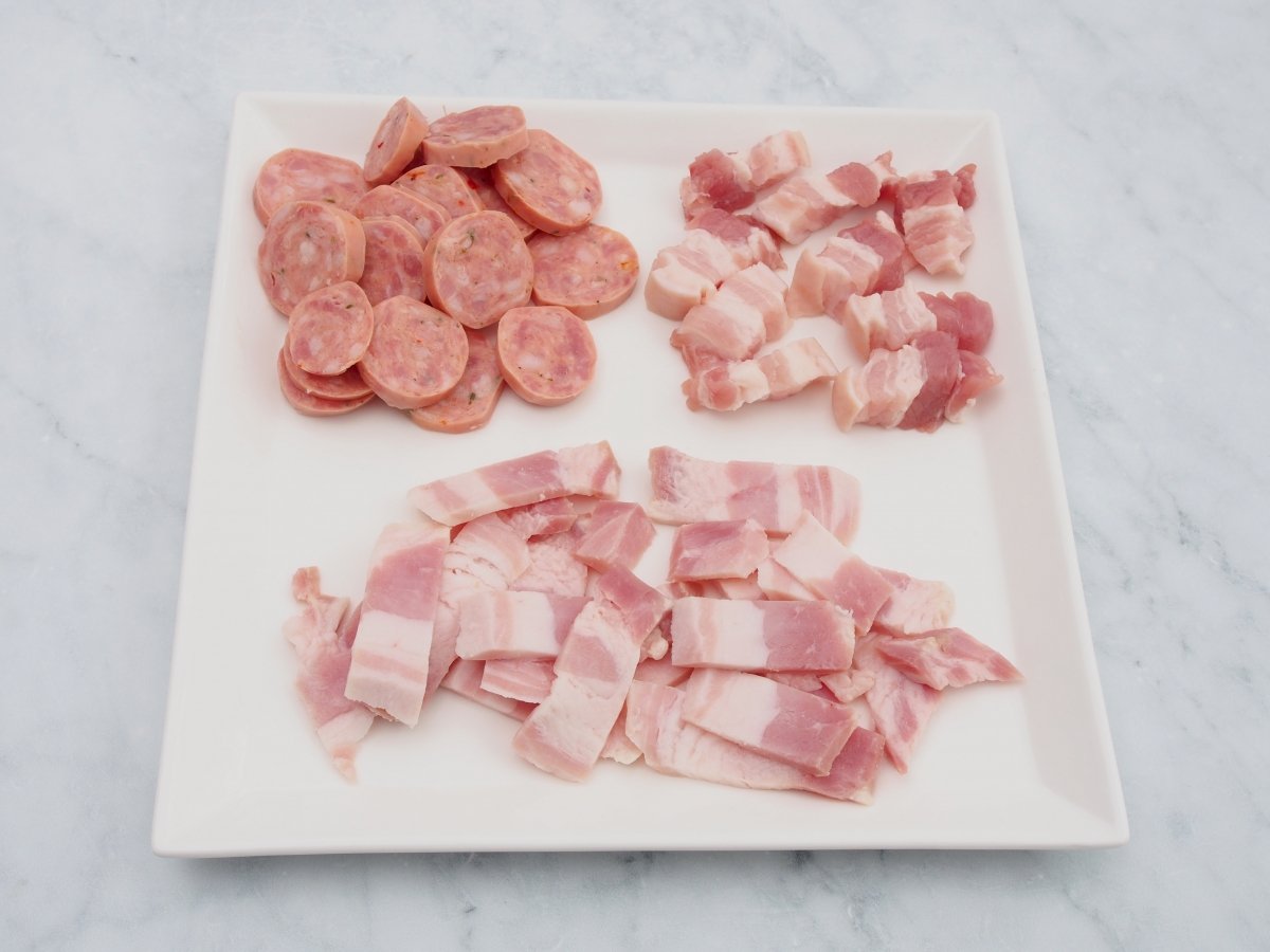 Cortar las carnes de cerdo para el arroz paisa