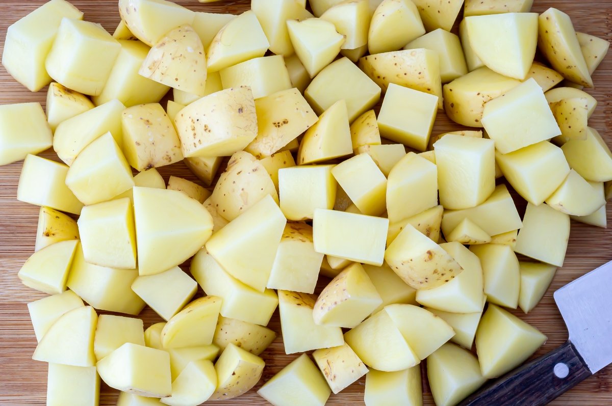 Cortar las patatas para la sopa de verdolaga