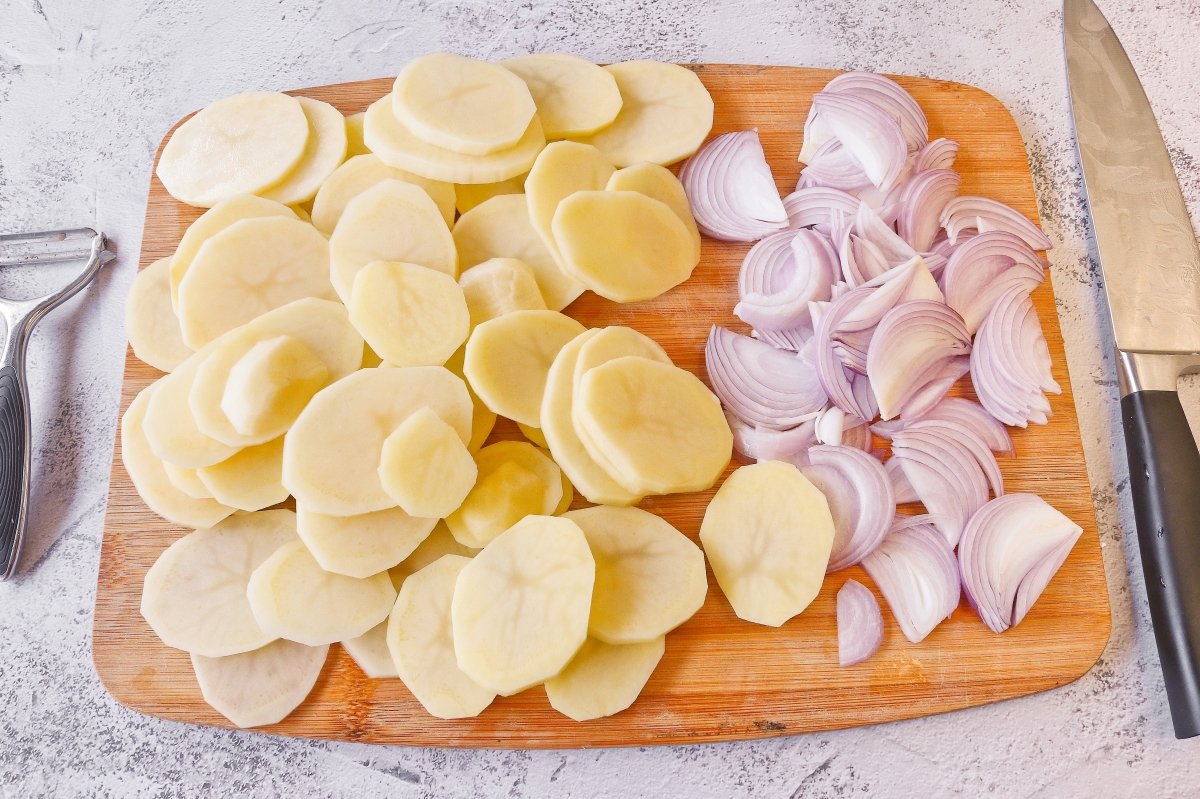 Cortar las patatas y la cebolla para la paletilla de cordero al horno