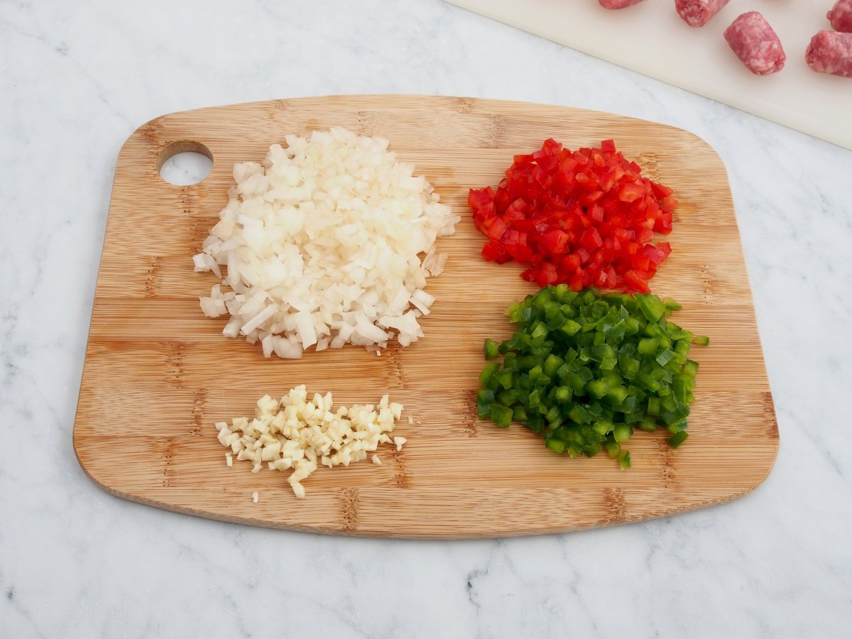 Cortar las verduras para el arroz con salchichas