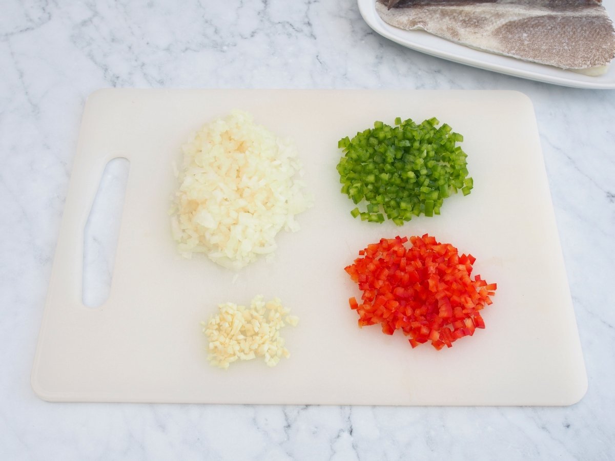 Cortar las verduras para el sofrito del arroz con bacalao