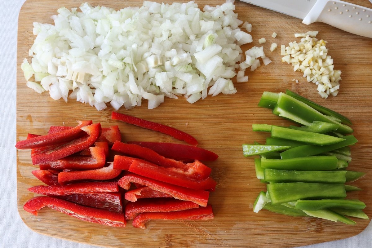 Cortar las verduras para los chorizos a la pomarola