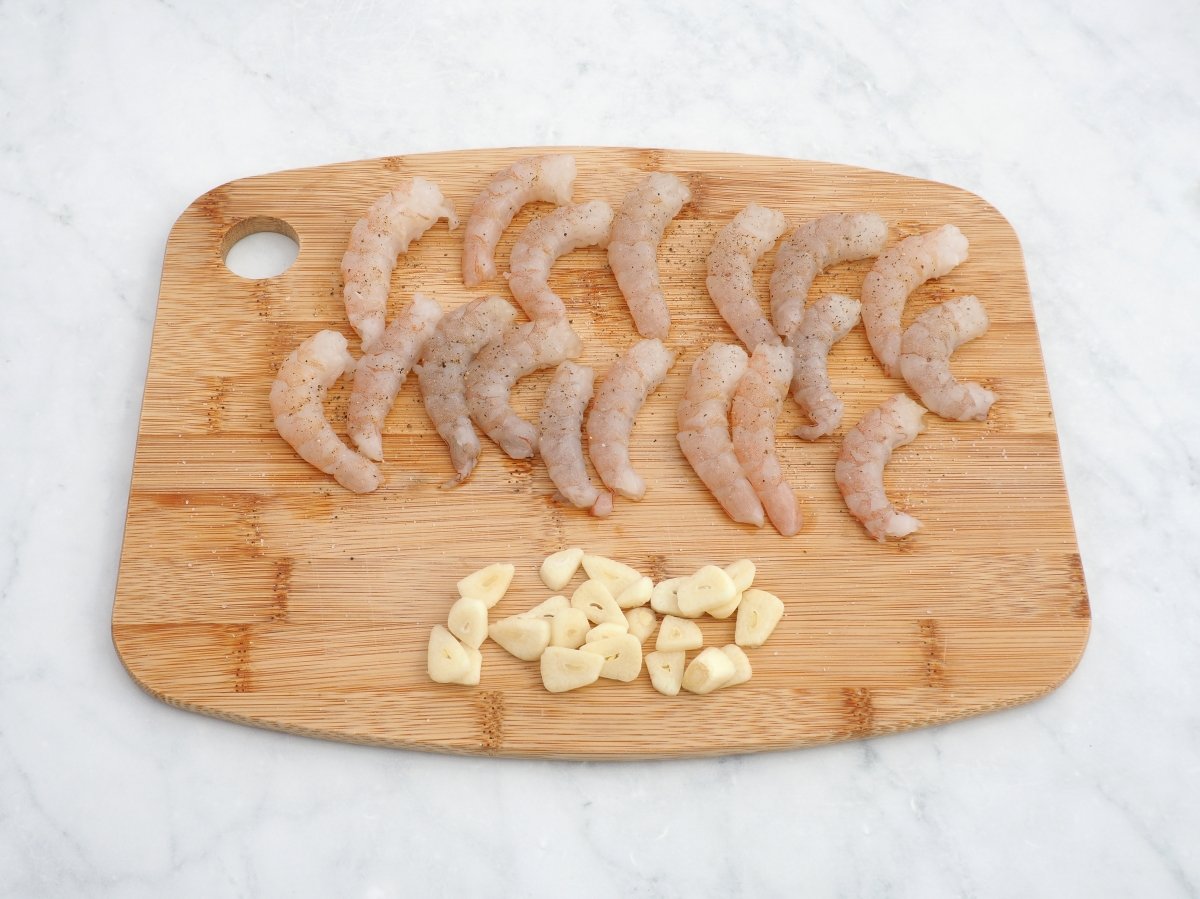 Cortar los ajos y salpimentar las gambas