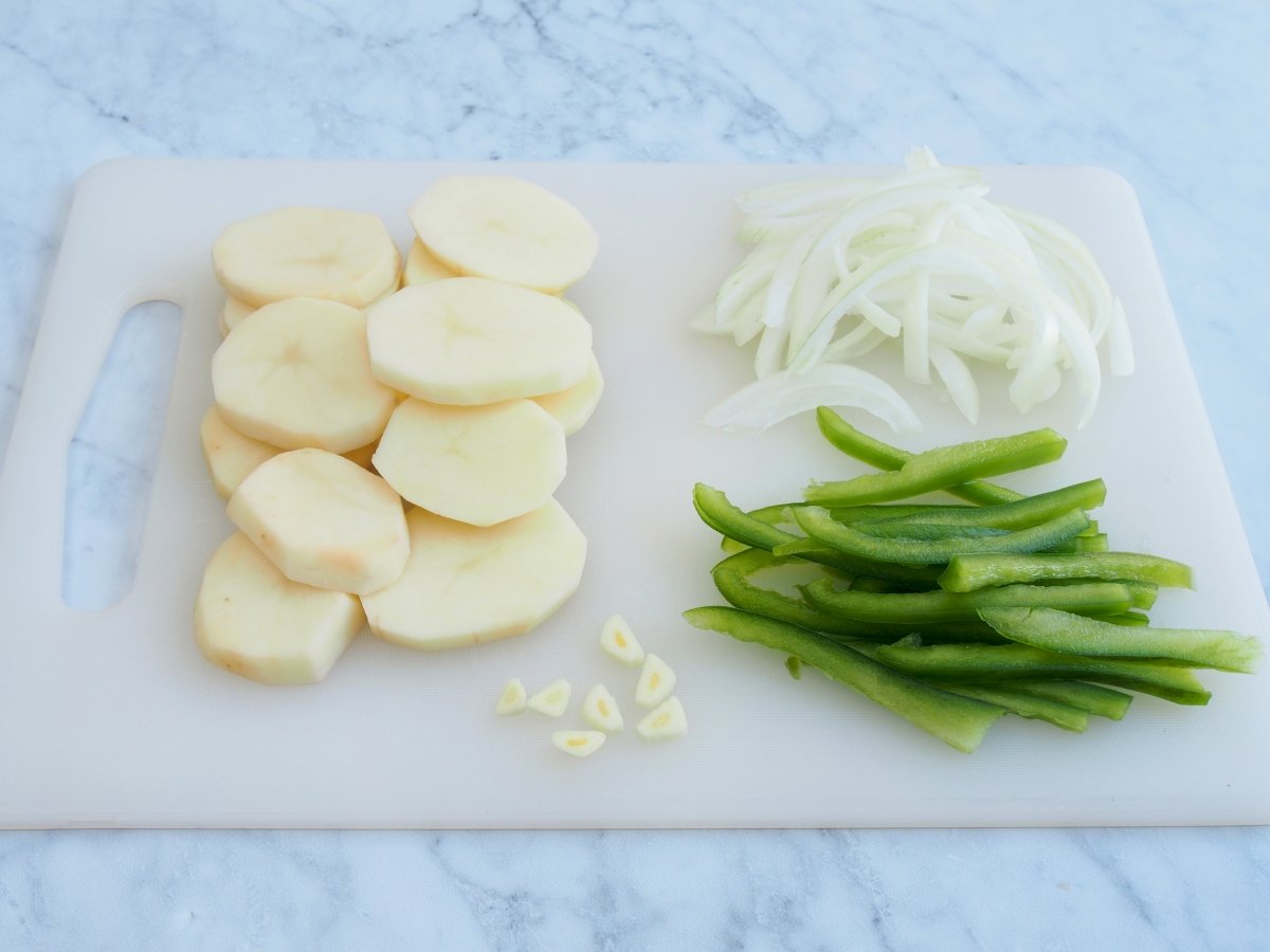 Cortar los ingredientes de las patatas a lo pobre