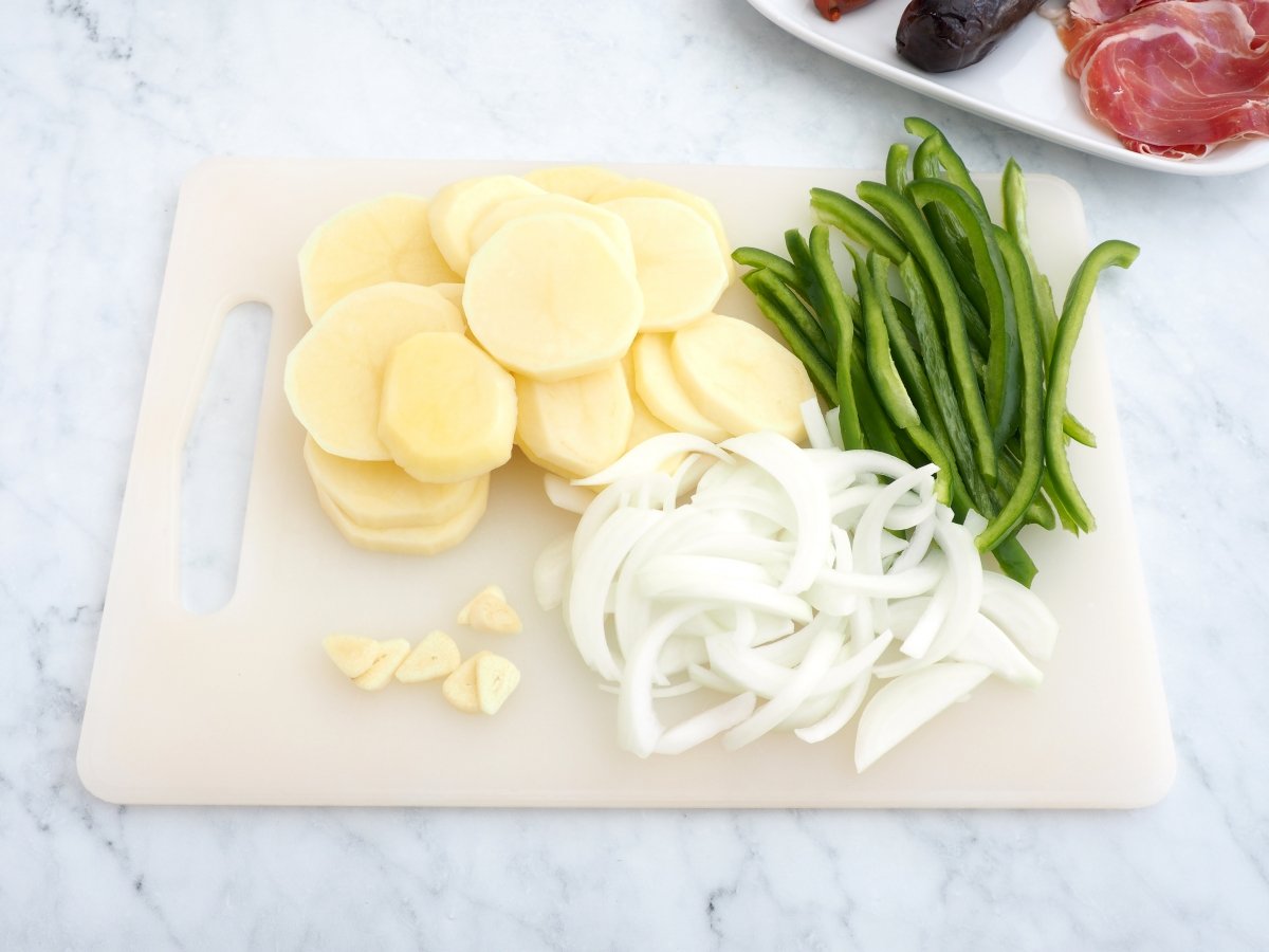 Cortar los ingredientes para las patatas a lo pobre