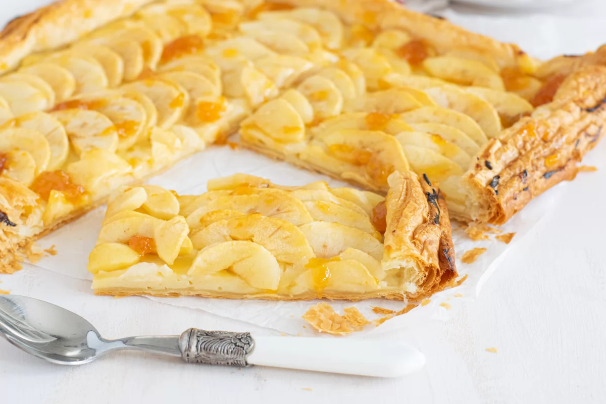 Corte de la tarta de manzana y hojaldre con crema pastelera