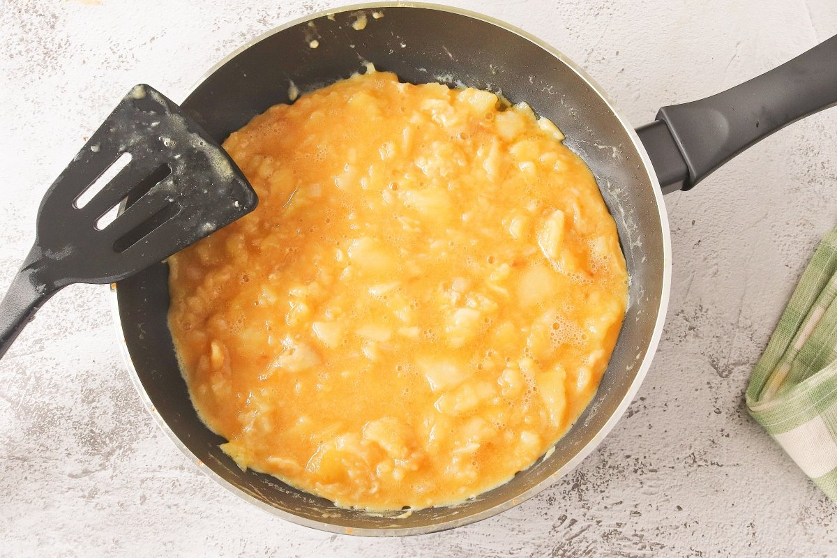 Cuajar la tortilla rellena de jamón y queso por un lado