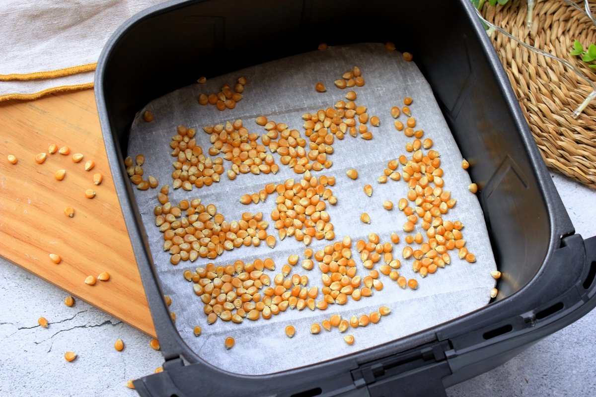 Cubeta de la freidora de aire con los granos de maíz dentro