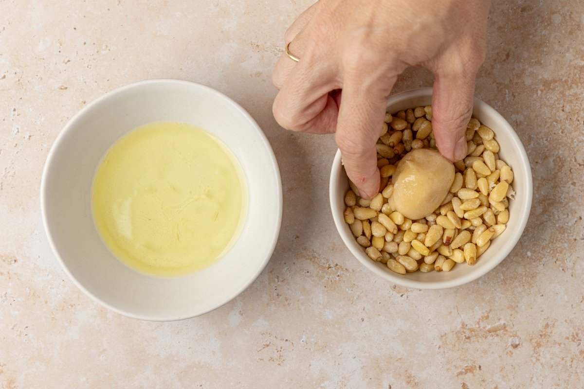 Cubriendo de piñones los panellets en Thermomix