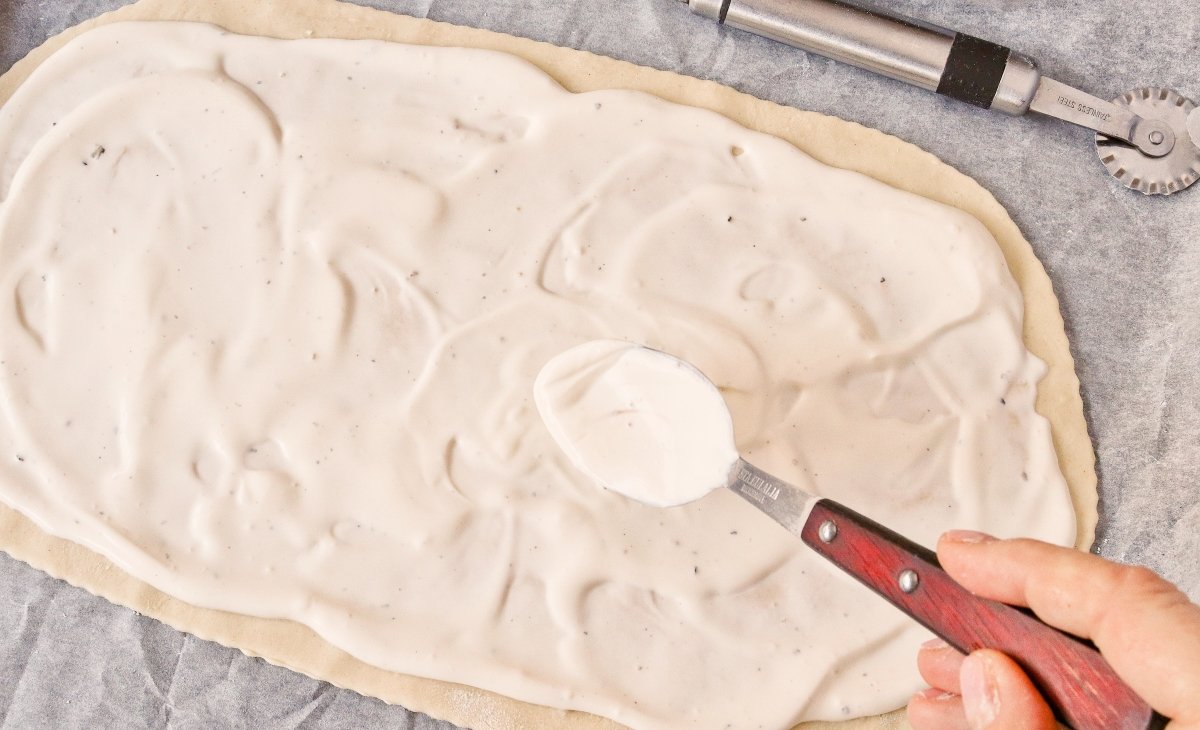 Cubrir con crema la masa del flammkuchen