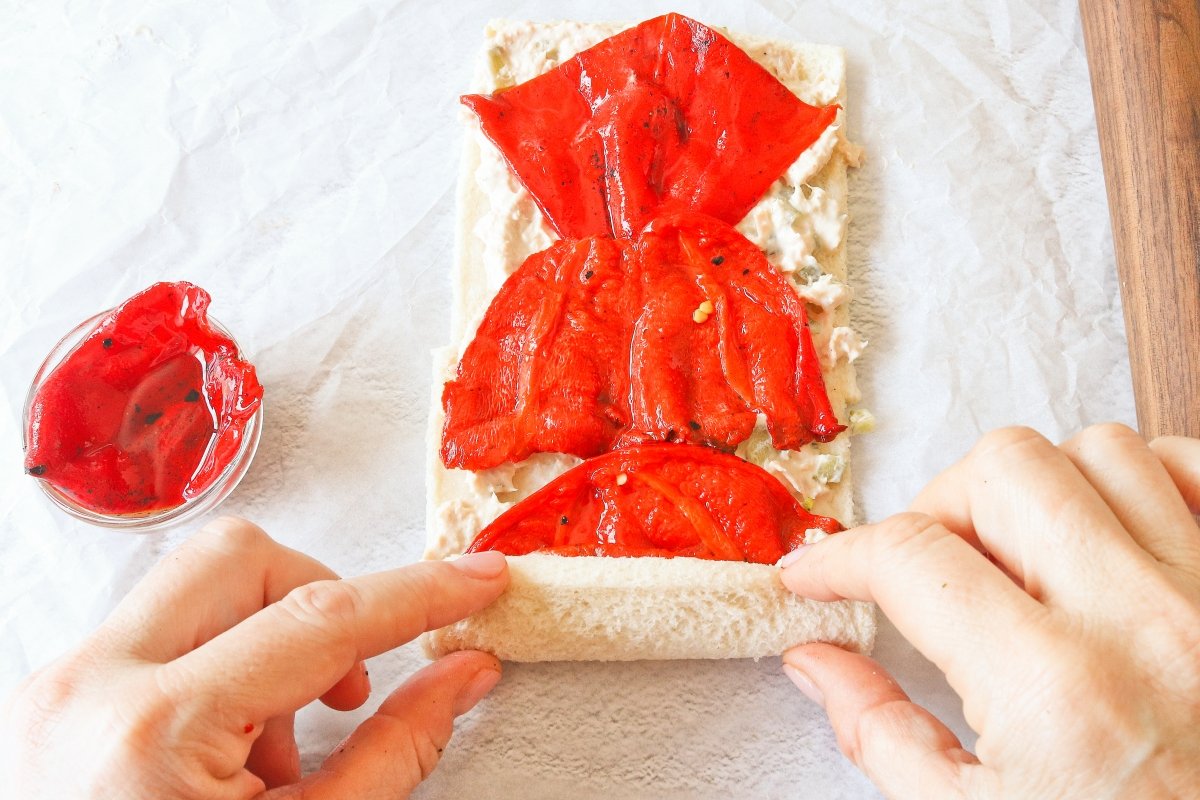 Cubrir con piquillos y enrollar el rollo de pan de molde