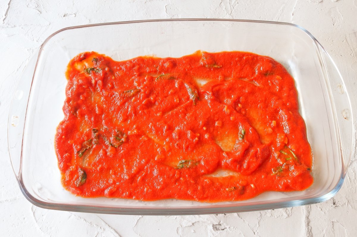 Cubrir con salsa marinara la base de la fuente de los manicotti