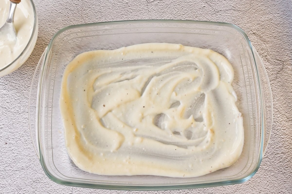 Cubrir la base de la fuente con bechamel para los canelones en freidora de aire
