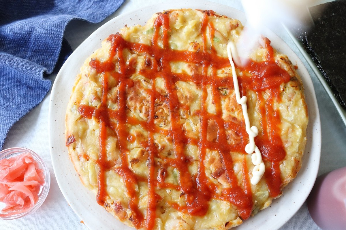 Cubrir la okonomiyaki con las salsas
