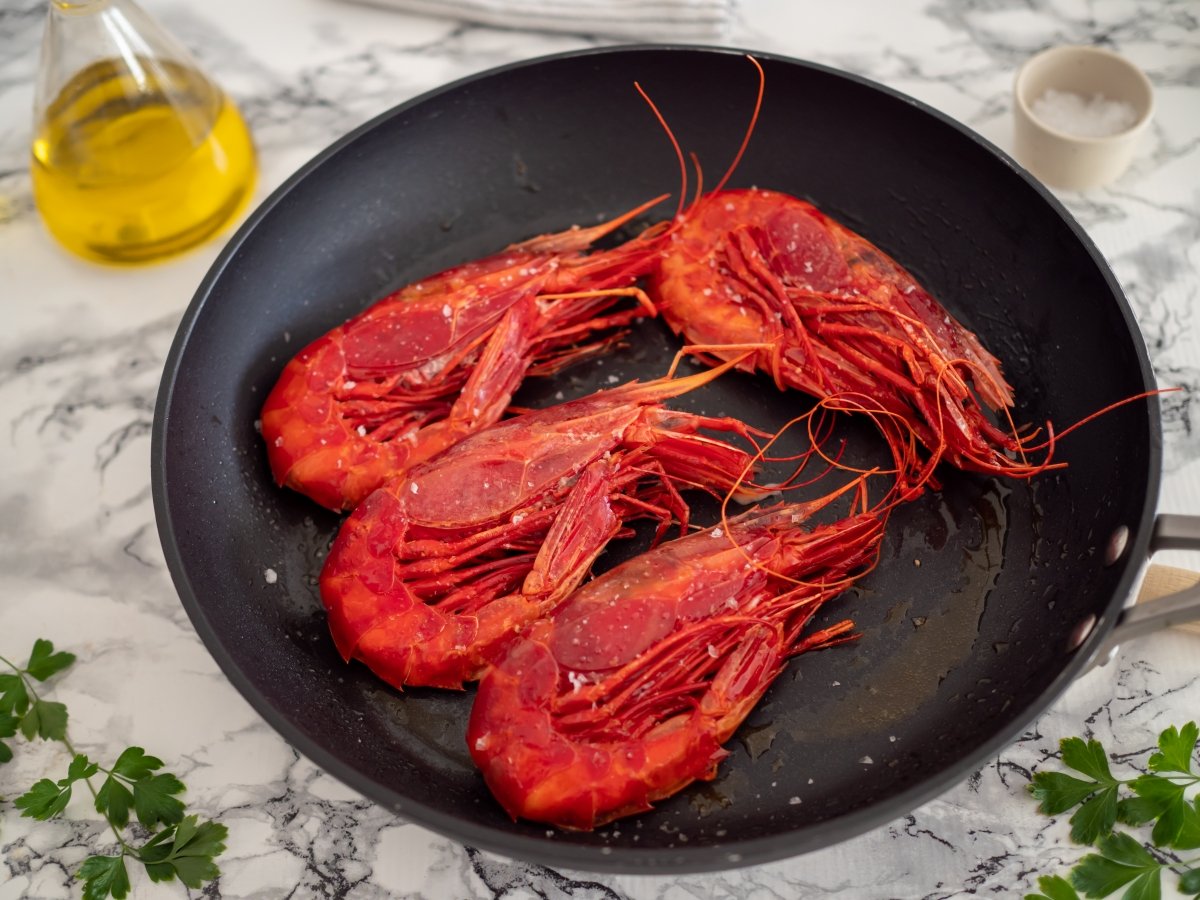 Turn the prawns over and add salt for the grilled prawns