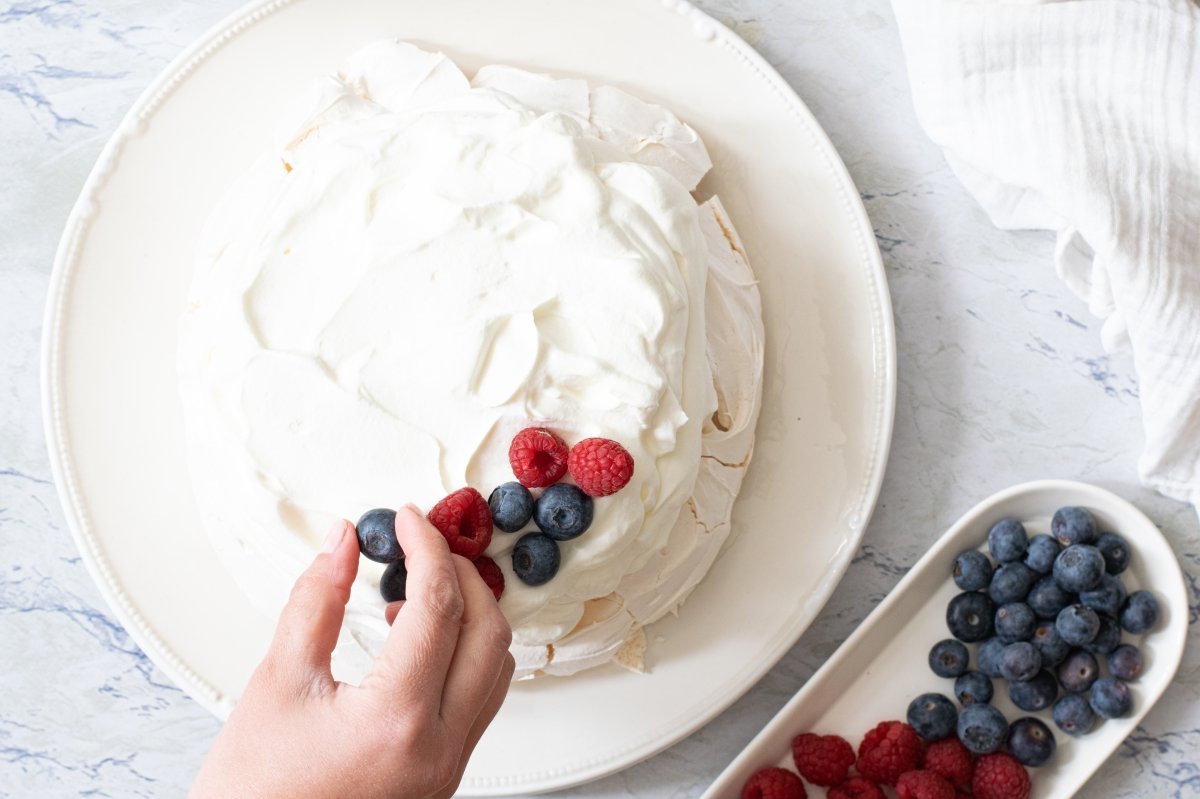 We decorate the Pavlova cake to taste with the red berries.