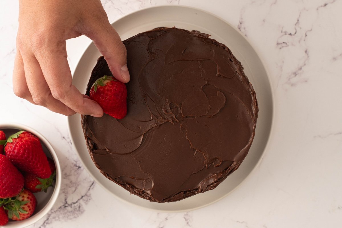 Decoramos la tarta de chocolate y fresas