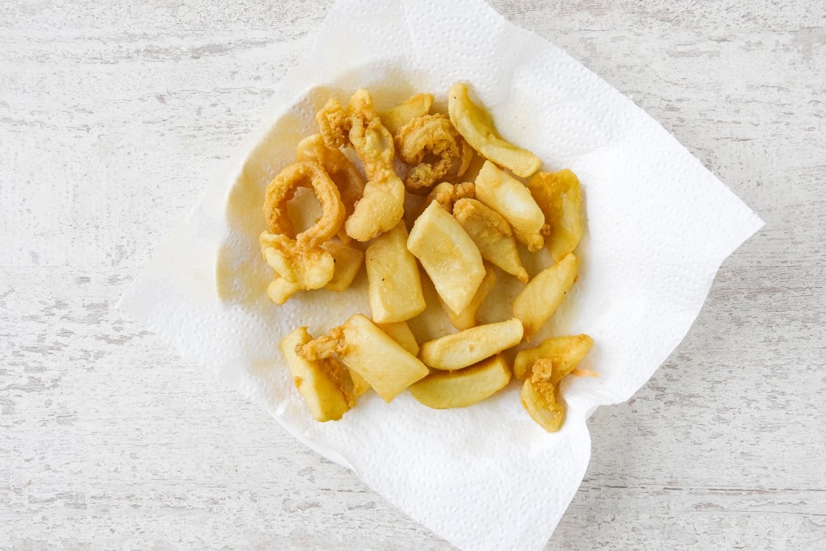 Dejamos escurrir la sepia rebozada sobre papel de cocina