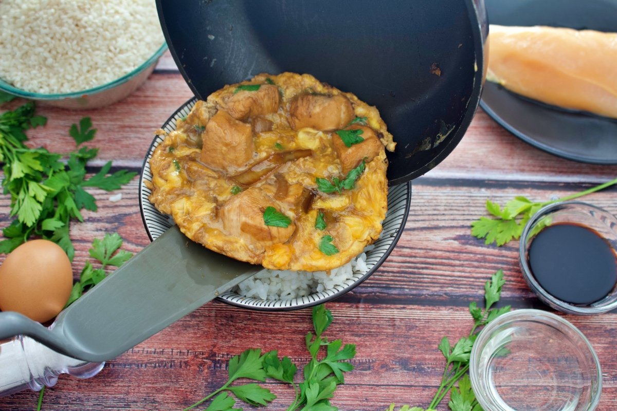 Dejando caer la mezcla sobre el arroz para seguir haciendo el oyakodon