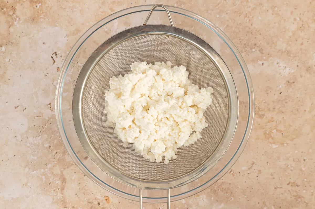 Dejar el queso ricotta en un colador para la torta pascualina