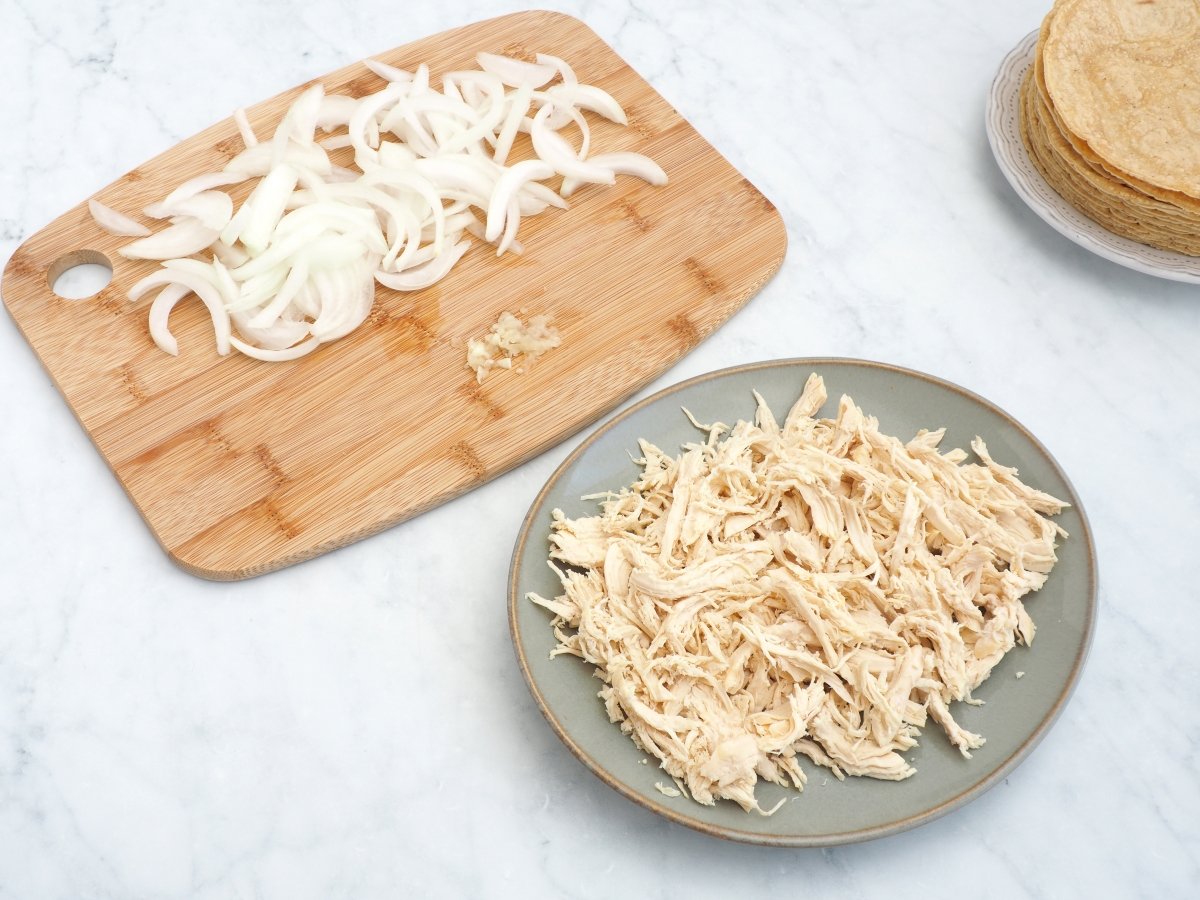 Deshebrar el pollo y cortar la cebolla