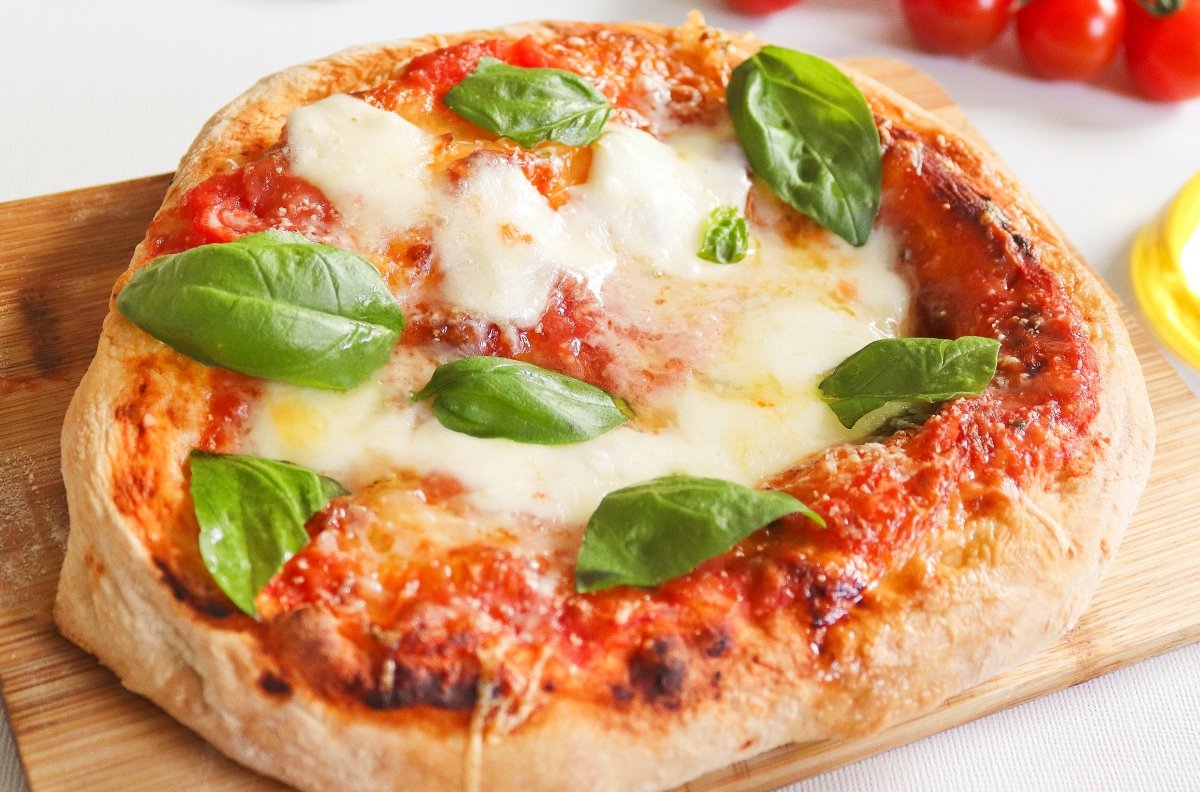 Detalle de un pizza con espinacas, queso y tomate