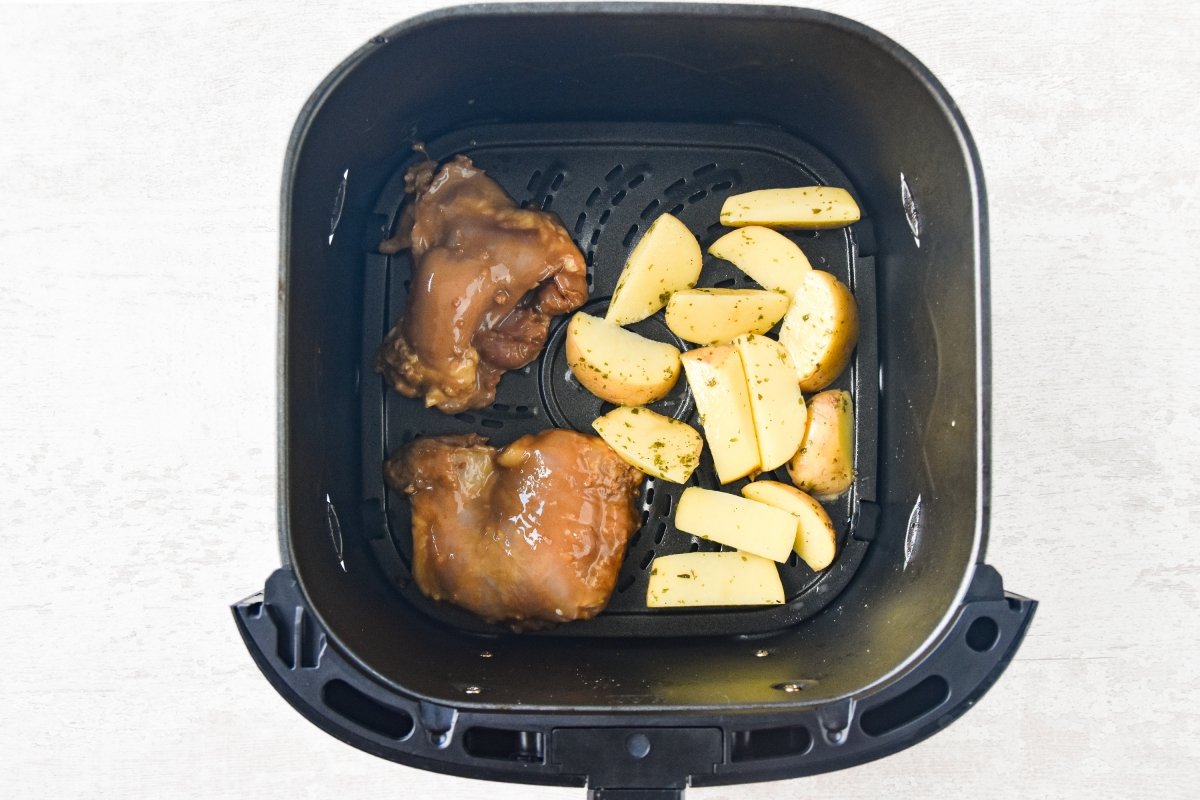 Disponemos el pollo y las patatas en el cesto de la freidora de aire