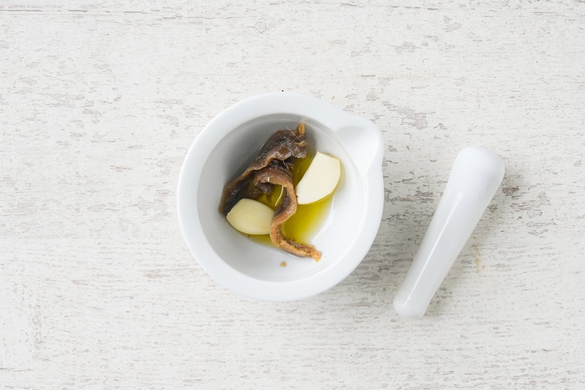 Disponemos las anchoas, el aceite y los ajos en el mortero
