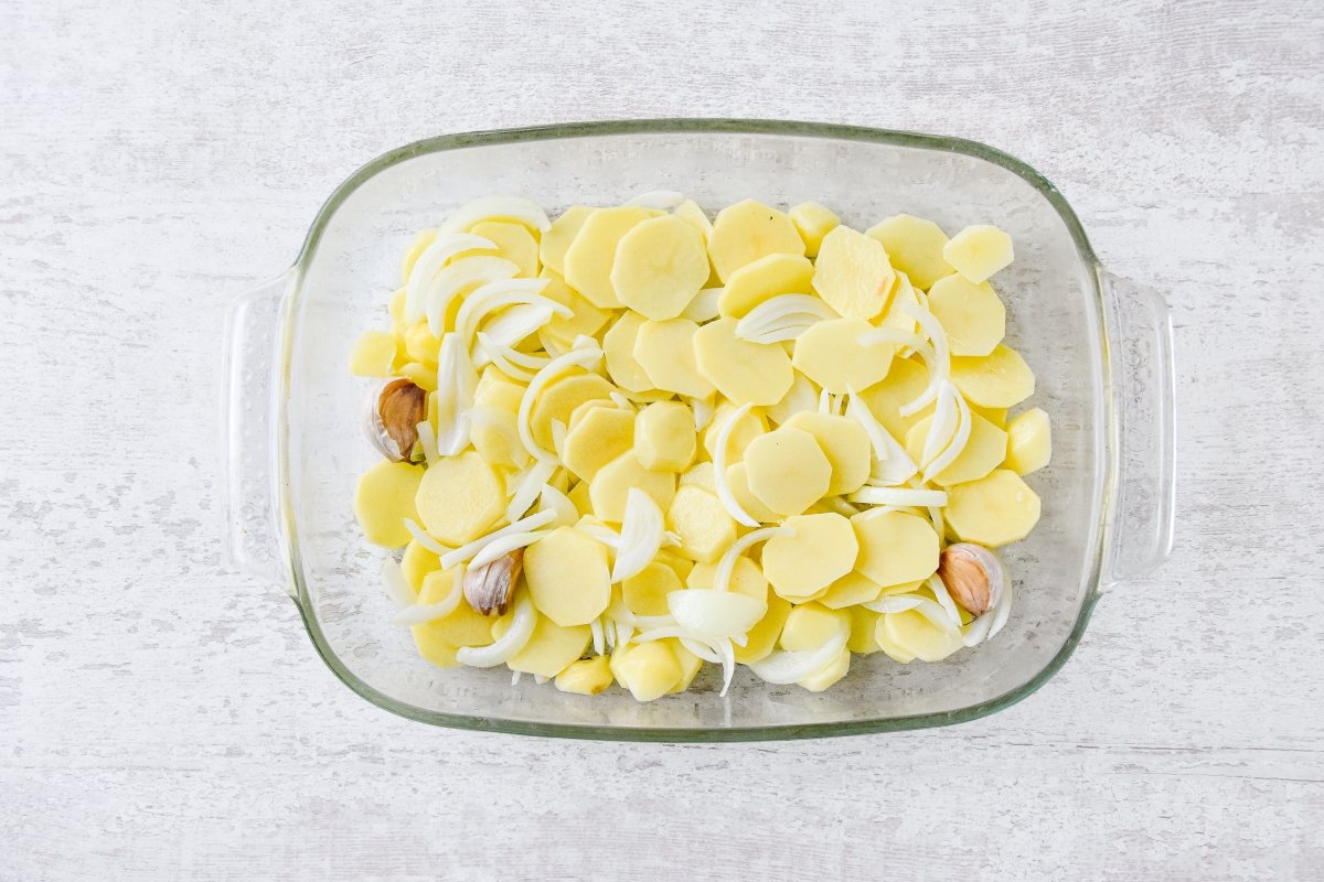Disponemos las patatas, la cebolla y los ajos en la bandeja