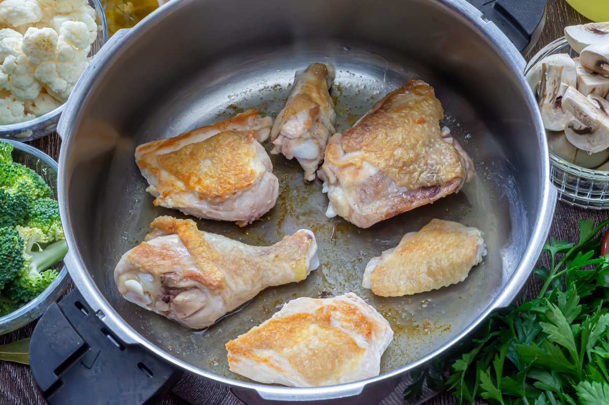 Dorar el pollo para el guiso con verduras