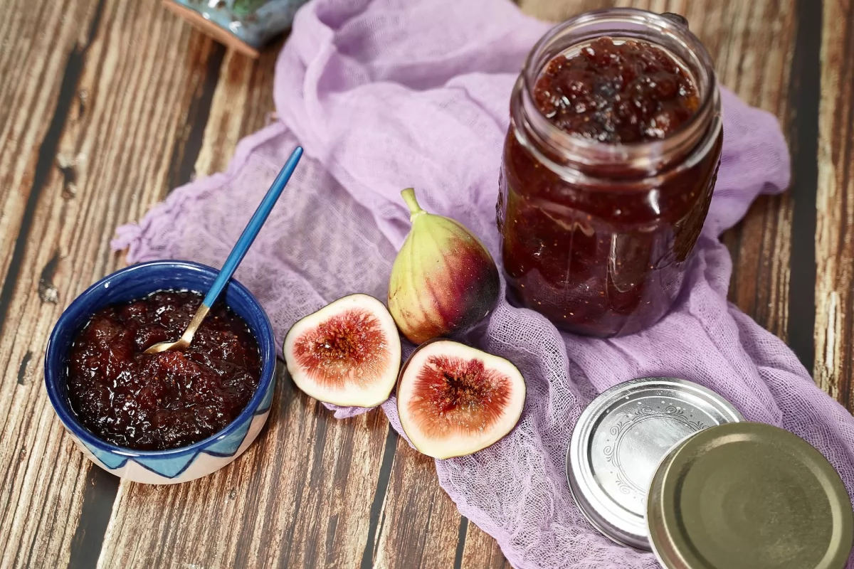 Dos higos y un tarro con confitura natural recién hecha y servida en un cuenco