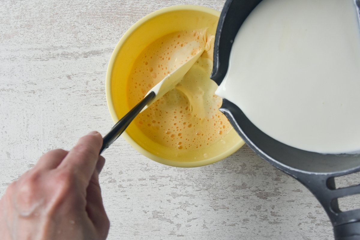 Echamos un poco de leche caliente sobre las yemas batidas