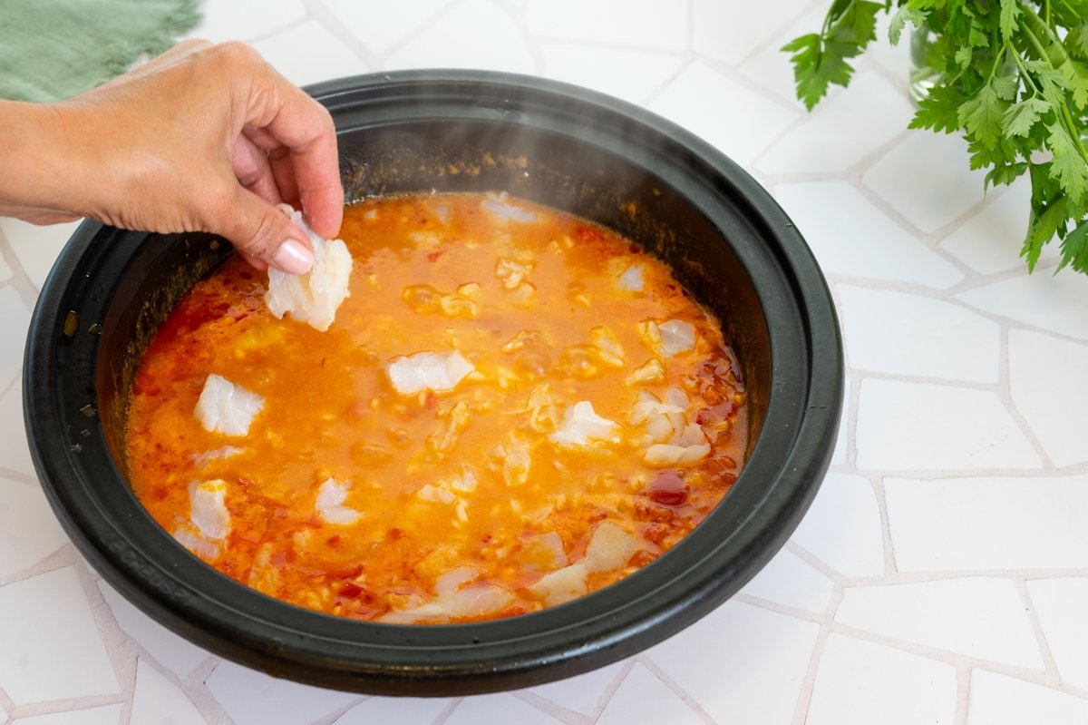 Echando el bacalao para hacer arroz caldoso con bacalao