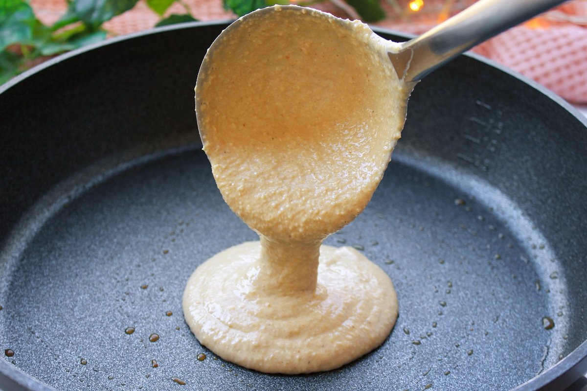 Scooping a ladle of pancake batter into the pan