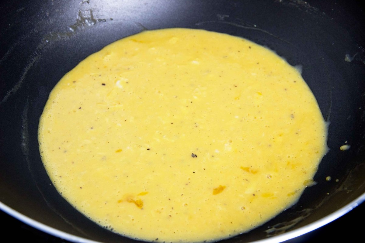 Echar los huevos batidos a la sartén y remover