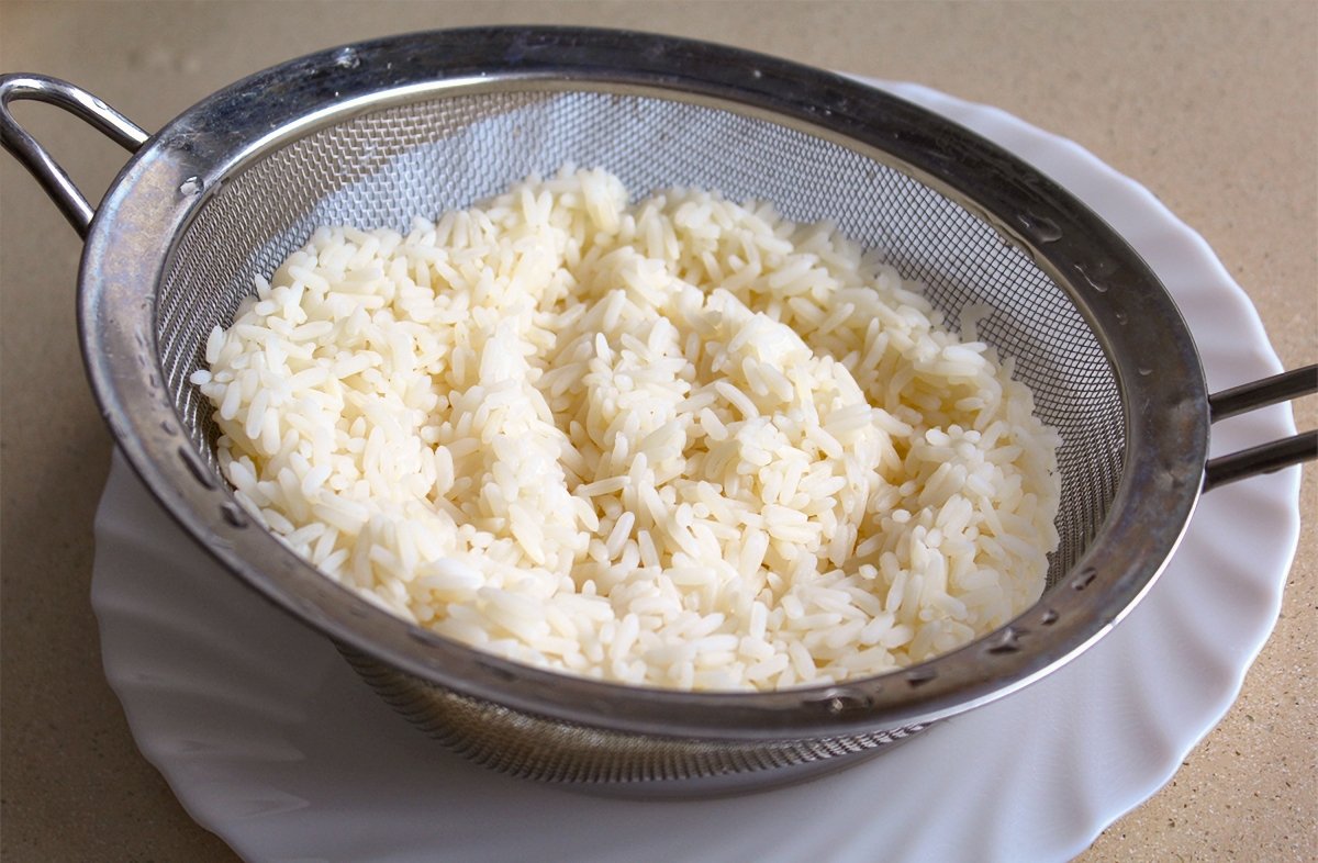 El arroz de la ensalada de arroz con mayonesa en el escurridor